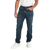 Jeans de hombre, corte slim, color azul oscuro con efecto lavado (dark stone). Presenta cierre de cremallera y botón, diseño de cinco bolsillos y parches con logo CAT en la cintura trasera y bolsillo trasero.