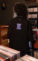 Remera de algodón premium con calce oversize, cuello redondo y mangas cortas. Presenta un estampado frontal gráfico con temática de Daft Punk en tonos verdes y violetas sobre fondo negro.