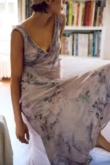 Vestido largo de viscosa con estampado abstracto en tonos tierra, verdes y azules. Presenta un escote en V profundo decorado con encaje, bordados y abalorios. Posee forro interior y cierre lateral oculto.