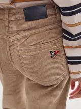 Pantalón de tiro medio confeccionado en pana color rojo, con corte holgado y detalle de línea lateral en contraste.