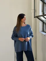 Sweater de punto color azul, con cuello redondo, corte holgado y mangas largas con puños ajustados.