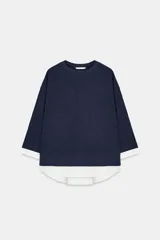 Sudadera azul marino de cuello redondo y manga larga, con detalle de aplicación de tejido blanco a contraste en el cuello, los puños y el bajo asimétrico.