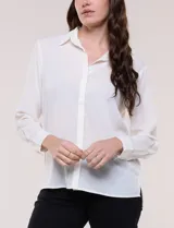 Camisa blanca de corte clásico y caída fluida, con cuello camisero tradicional, abotonadura frontal oculta y mangas largas con puños anchos.
