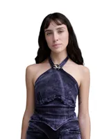 Top halter de denim con efecto lavado, corte entallado y escote alto. Presenta recortes frontales estructurados, terminación desflecada en el frente y un aplique metálico decorativo en el centro del cuello.