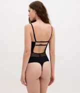 Body de tul negro con diseño de espalda descubierta, breteles finos ajustables y detalle de elástico decorativo con patrón geométrico en la cintura. Confeccionado en tejido transparente con forro de algodón.