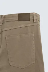 Pantalón de corte recto confeccionado en tejido de algodón con elasticidad. Presenta diseño de cinco bolsillos, cierre frontal con cremallera y botón.