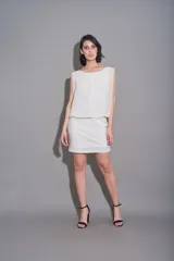 Vestido corto blanco con falda de encaje y top de gasa sin mangas.