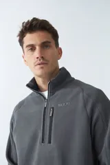 Buzo polar de algodón azul marino con cuello elevado, logo estampado, bolsillo frontal con cierre y medio cierre frontal.