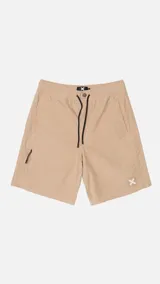 Shorts de color beige con cintura elástica y cordón ajustable. Presenta un bolsillo lateral con cierre y un pequeño logo bordado en la parte inferior derecha.