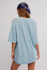 Remera oversize de manga corta a rayas celestes y blancas, con cuello redondo y un bolsillo aplicado en el pecho.