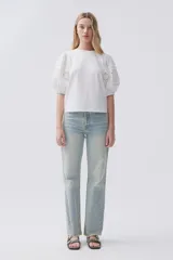 Jean celeste de calce recto, tiro medio-alto, lavado claro y ruedo desflecado.