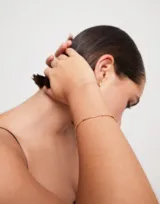 Pulsera dorada con eslabones formados por bolitas y piezas alargadas.