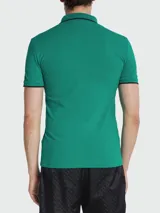 Remera polo de algodón, color verde, de corte slim fit, con cuello y puños ribeteados en negro y tres botones frontales.