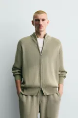 Chaqueta relaxed fit de tejido de punto de algodón, color verde militar, con cuello subido, manga larga, acabados en rib y cierre frontal con cremallera. Presenta efecto lavado.