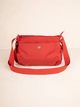 Bandolera de nylon color rojo con correa regulable. Tiene tres compartimentos, un bolsillo interno y dos bolsillos laterales con elástico.