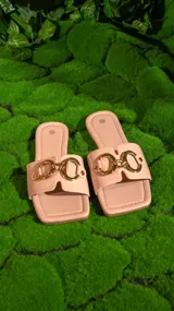 Sandalias chatas color rosa nude, con base cuadrada y tira ancha sobre el empeine adornada con eslabones dorados.