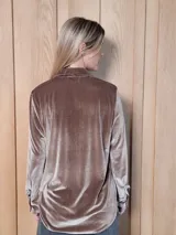 Camisa de jean de corte clásico, con cuello camisero, cierre frontal con botones y mangas largas con puños abotonados.