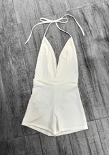 Mono corto de color rojo, con escote halter y espalda descubierta.