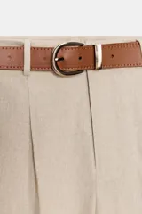 Pantalón tobillero azul marino de tiro medio, con pinzas delanteras, bolsillos frontales, falsos bolsillos con solapa en la espalda y cierre frontal con cremallera, botón y gancho. Incluye cinturón de cuero sintético tostado con hebilla metálica dorada.