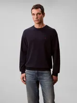 Sweater Calvin Klein de punto color azul marino, con cuello redondo, mangas largas y detalles acanalados en cuello, puños y bajo. Presenta un discreto monograma CK bordado en rojo en el pecho.