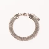 Pulsera de acero plateado con múltiples cadenas finas entrelazadas, cierre de mosquetón y cadena de extensión con dije circular.