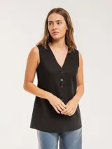 Chaleco color crema de lino con corte sastrero, largo a la cadera, forro interno, botones delanteros, silueta levemente entallada y tajo cruzado en la espalda.