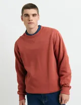 Sweater básico de cuello redondo y manga larga, confeccionado en tejido circular con puños y cuello en tejido canalé.