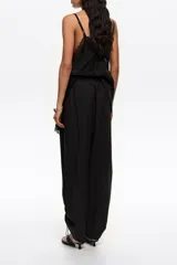 Pantalón jogger negro confeccionado en mezcla de lyocell y algodón, de tiro medio con bolsillos laterales y bajos ajustables mediante cordones elásticos con stoppers.