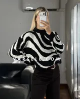 Sweater de tejido de punto con diseño de ondas en color marrón y crema, de cuello redondo y manga larga.