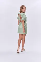 Vestido corto verde de lino, con escote cuadrado, mangas abullonadas cortas y corte recto.