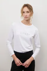 Remera de manga larga en color blanco, confeccionada en tejido suave y liviano. Presenta un delicado bordado lineal en el centro del pecho con motivos temáticos de desayuno.