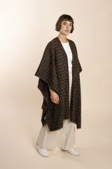 Ruana de lana fina color crudo con terminación envivada.