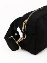 Bandolera negra de diseño rectangular con cierre superior y correa ajustable extraíble. Presenta un detalle circular central y herrajes metálicos dorados.