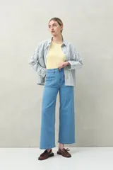 Pantalón jean celeste de tiro alto y corte ancho, con bolsillos delanteros tipo parche.