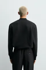 Sudadera de corte regular fit confeccionada en tejido de algodón con interior de rizo. Presenta cuello tipo rib, cierre frontal de cremallera y acabados en rib en puños y bajo.