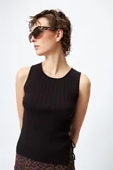 Musculosa blanca de tejido acanalado con detalle de trenzado lateral ajustable.