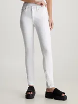 Pantalón de jean blanco, corte skinny, tiro medio, con bragueta con cremallera y diseño de cinco bolsillos.