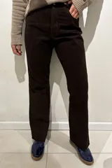 Pantalón de cuero ovino italiano, de corte recto y tiro medio, con cierre frontal y bolsillos laterales.