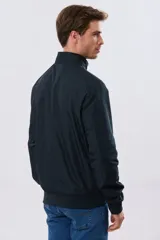 Campera liviana de nylon color azul marino, con cuello alto, cierre frontal y puños y dobladillo en elástico tejido.