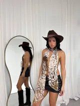 Top halter con estampado animal print de vaca, con tiras finas que se atan en la nuca y en la espalda.