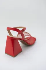 Sandalias rojas con capellada de cuero y rejilla, taco geométrico y pulsera al tobillo.