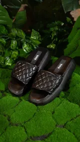 Sandalias bajas color beige con plataforma y tira ancha acolchada con diseño de rombos.