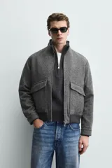 Cazadora relaxed fit de mezcla de lana color gris oscuro, con cuello subido, bolsillos delanteros con solapa, cierre frontal de cremallera y bajo acabado en rib.