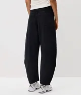 Pantalón baggy balloon de jean negro, con cintura media, cierre frontal con fila de botones y bolsillos funcionales.