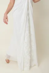 Vestido largo de gasa de seda natural color blanco, con breteles y frente con apliques de flores y bordados.