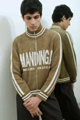 Campera tejida de algodón en color bordó y blanco, con cuello alto, cierre frontal completo y diseño con estampado tipográfico.