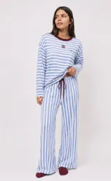 Pijama set compuesto por remera de manga larga y pantalón a rayas celestes y blancas con detalles en color bordo.