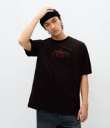 Remera de algodón con cuello redondo y mangas cortas. Presenta una estampa en la espalda que muestra el rostro de The Notorious B.I.G. con una corona, junto con una firma en la parte inferior.