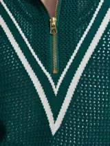 Sweater de punto verde oscuro con cierre dorado y cuello polo. Presenta un diseño en V blanco en el pecho.