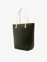 Bolso tipo tote de chenilla color verde oscuro con ribete amarillo. Tiene dos correas de hombro color crema, compartimento principal con bolsillos internos y apliques metálicos con el logo de la marca.